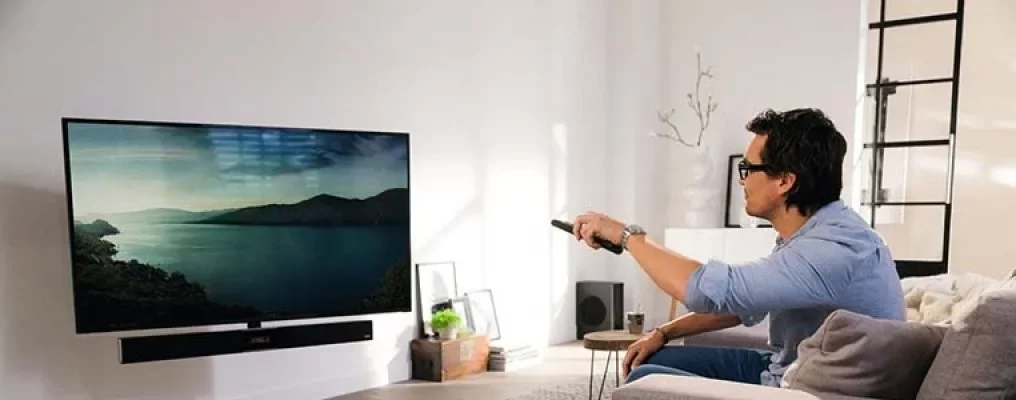 man turning on a tv from the sofa